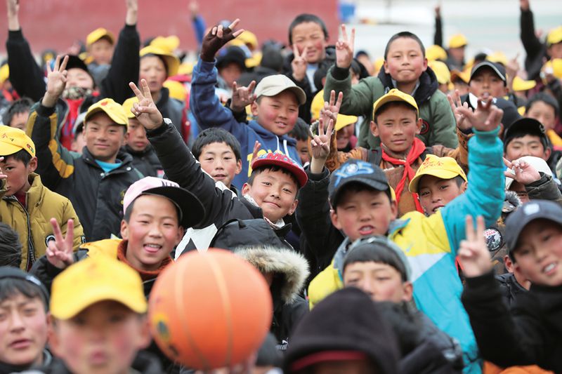 Young Tibetan students throw up peace signs outside school in Ningbo, China.